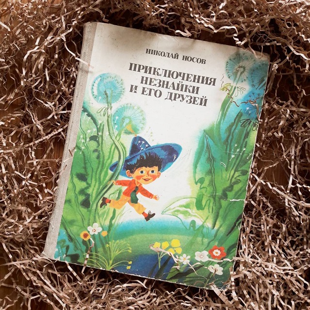 Приключения незнайки 1 книга. Приключения Незнайки и его друзей книга. Незнайка Носов книга. Незнайка с книжкой.